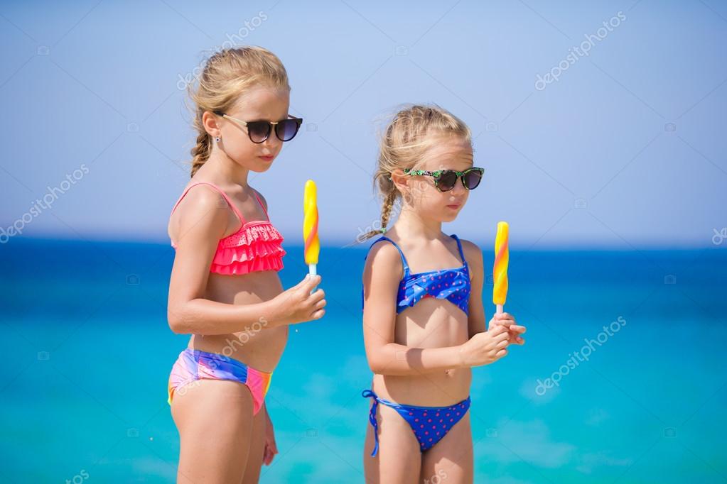 Niñas felices comiendo helado durante las vacaciones en la playa. Gente,  niños, amigos y concepto de amistad: fotografía de stock © d.travnikov  #122935056