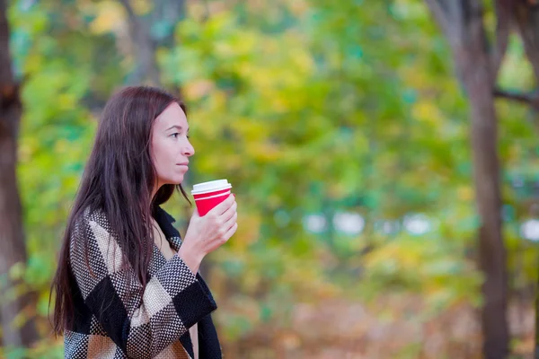 美丽的女人喝咖啡在秋天公园下秋天的落叶。咖啡要走 — 图库照片