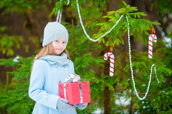 Adorable chica con regalo caja de Navidad en invierno al aire libre en la víspera de Navidad — Foto de Stock