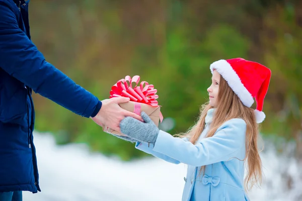 Adorable niña dando regalo caja de Navidad en invierno al aire libre — Foto de Stock