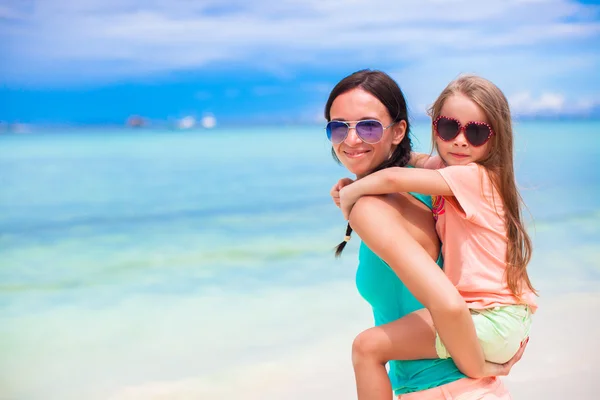 Kleines Mädchen und junge Mutter im Strandurlaub — Stockfoto