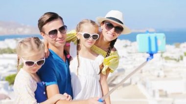 Avrupa'nın aile tatili. Ebeveynler ve çocuklar selfie fotoğraf arka plan Mikonos kentine Yunanistan alarak