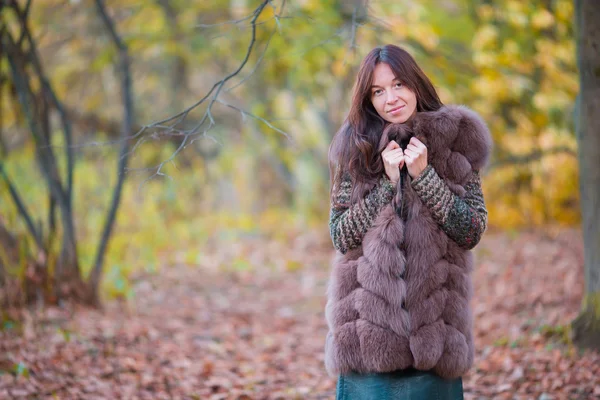 Beautiful elegant woman standing in a park in autumn — Stock Photo, Image