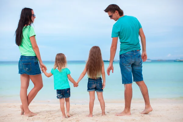 Família feliz de quatro na praia — Fotografia de Stock