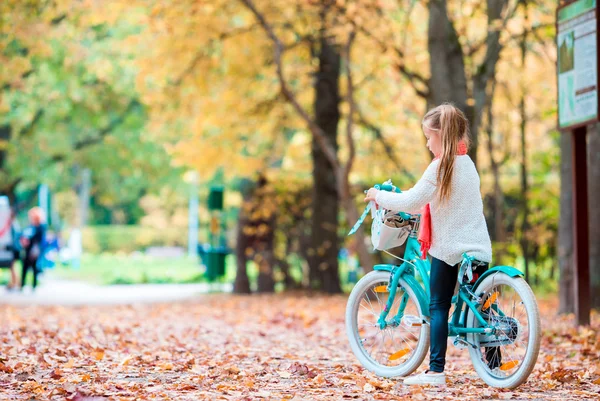 Bedårande flicka rida en cykel på vacker höstdag utomhus — Stockfoto