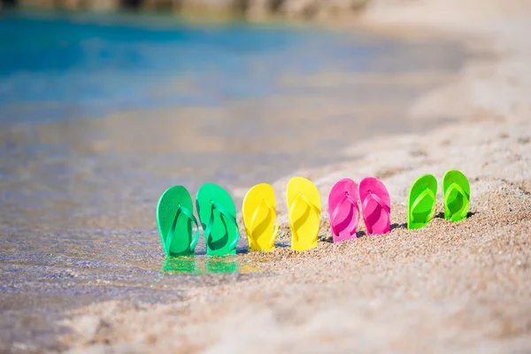 Family flip flops on beach in front of the sea — Stock Photo, Image