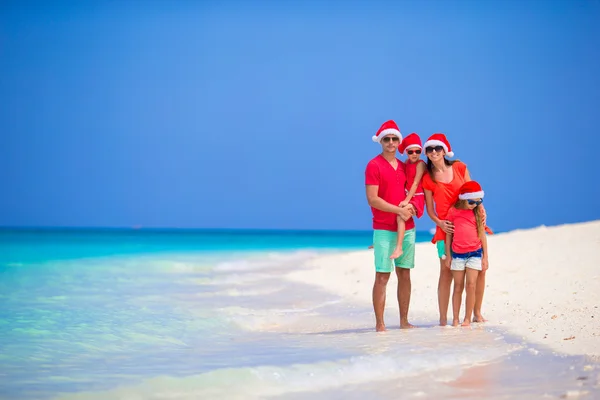 Gelukkige familie in Santa hoeden tijdens tropische kerstvakantie — Stockfoto