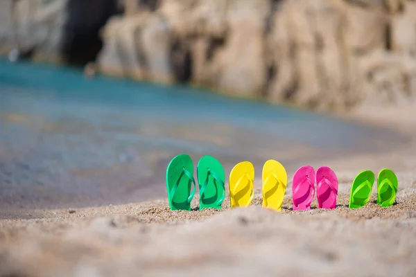 Family flip flops on beach in front of the sea — Stock Photo, Image
