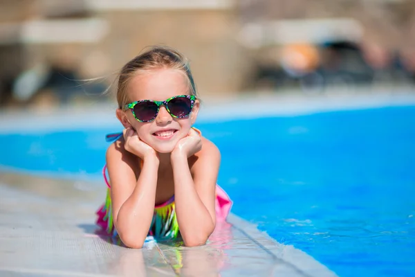 Adorable niña en la piscina divirtiéndose durante las vacaciones de verano —  Fotos de Stock