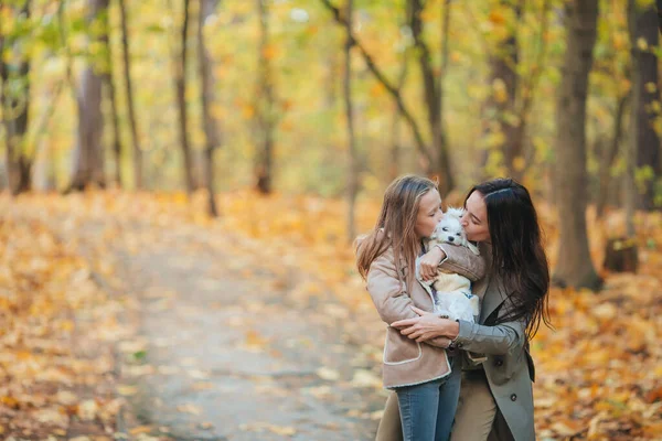 Klein meisje met mam buiten in park in de herfst dag — Stockfoto