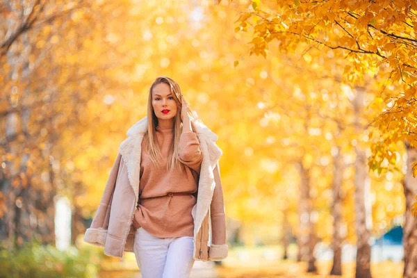 Herfstconcept - mooie vrouw in herfstpark onder herfstblad — Stockfoto