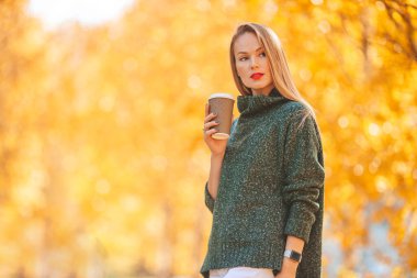 Sonbahar konsepti: Sonbahar parkında sonbahar yeşilliği altında güzel bir kadın.