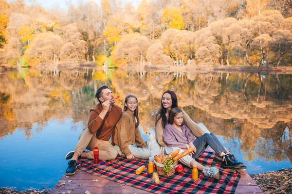 Bella famiglia in autunno calda giornata vicino al lago — Foto Stock