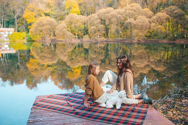 Mooie familie in de herfst warme dag in de buurt van meer — Stockfoto