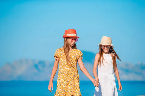 Little happy funny girls have a lot of fun at tropical beach playing together — Stock Photo, Image