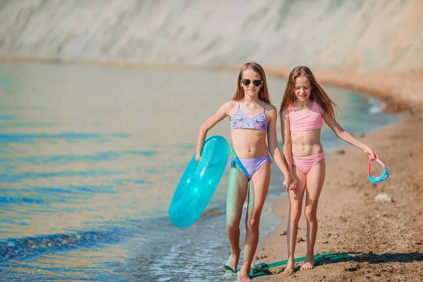 Poco feliz divertido niñas tienen un montón de diversión en la playa jugando juntos —  Fotos de Stock