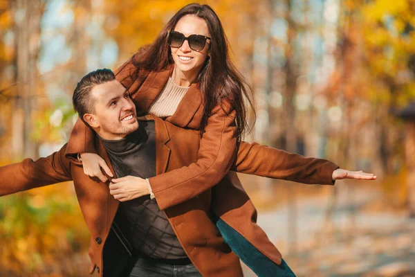 Familia feliz caminando en el parque de otoño en el soleado día de otoño —  Fotos de Stock