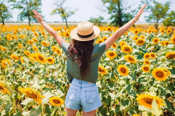 Junge Frau genießt die Natur auf dem Sonnenblumenfeld. — Stockfoto