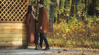 Mutlu aile, sonbahar parkında güneşli sonbahar gününde yürüyor.