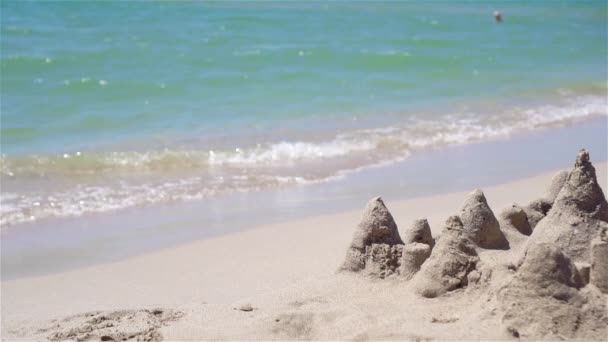 Castillo de arena en la playa tropical blanca con juguetes de plástico para niños — Vídeo de stock