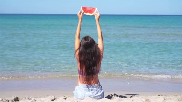 Gelukkig meisje het hebben van plezier op het strand en het eten van watermeloen — Stockvideo