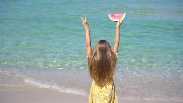 Gelukkig meisje het hebben van plezier op het strand en het eten van watermeloen — Stockvideo