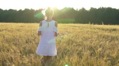 Açık buğday tarlasında mutlu tatlı bir kız.