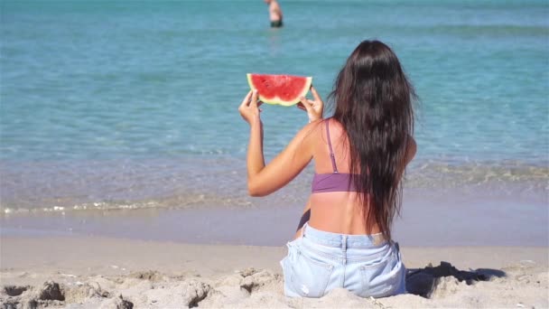 Chica feliz divirtiéndose en la playa y comiendo sandía — Vídeos de Stock