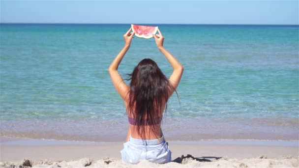 Mutlu kız sahilde eğleniyor ve karpuz yiyor. — Stok video