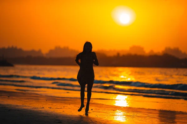 Adorable niña feliz en la playa blanca al atardecer. — Foto de Stock