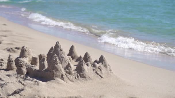 Castillo de arena en la playa tropical blanca con juguetes de plástico para niños — Vídeo de stock