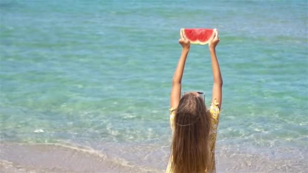 Gelukkig meisje het hebben van plezier op het strand en het eten van watermeloen — Stockvideo