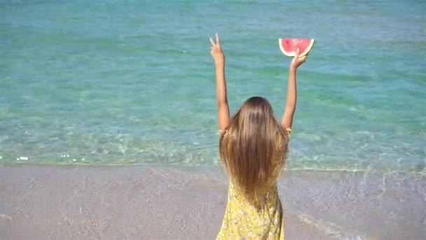 Gelukkig meisje het hebben van plezier op het strand en het eten van watermeloen — Stockvideo