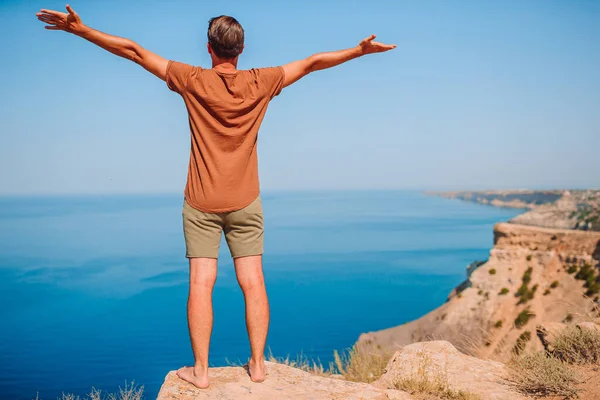 Tourist man outdoor on edge of cliff seashore — Stock Photo, Image