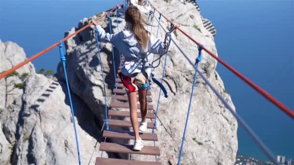 Chicas cruzando el abismo en el puente de cuerda. El fondo negro de mar, la Crimea — Vídeo de stock