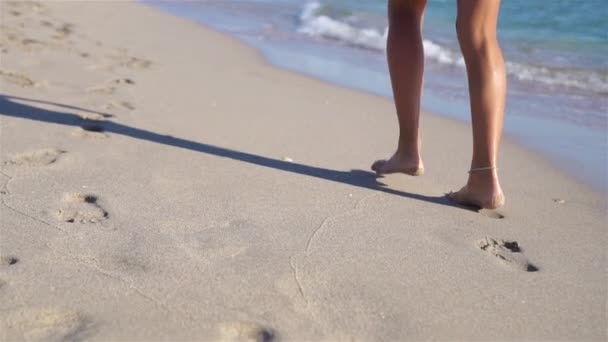 Женские ноги на белом песчаном пляже на фоне моря — стоковое видео