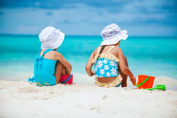 Två små glada flickor har mycket roligt på tropiska stranden leker tillsammans — Stockfoto