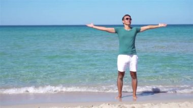 Beyaz sahildeki genç adam tatilde.