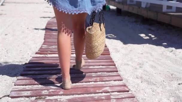Жіночі ноги на білому піщаному пляжі на фоні моря — стокове відео