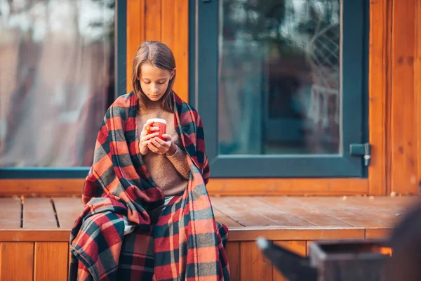 Belle fille enveloppée dans une couverture à l'automne jour chaud — Photo