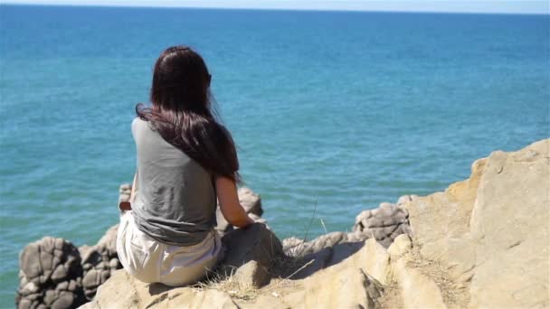 Turistkvinna utomhus på kanten av klippan stranden — Stockvideo