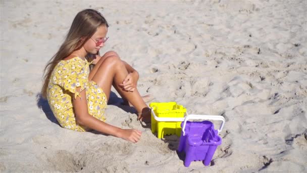 Kislány a trópusi fehér strandon, homokvárat csinál — Stock videók