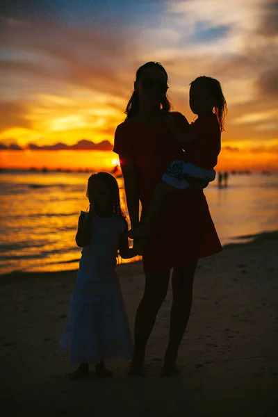 Vacker mor och dotter på stranden njuta av solnedgången utsikt — Stockfoto