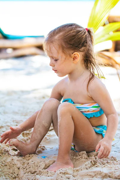 Menina na praia branca tropical fazendo castelo de areia — Fotografia de Stock