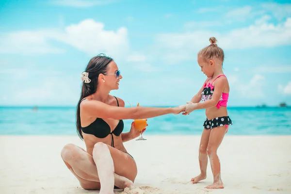Tatlı küçük kızlar ve genç anne tropikal beyaz plajda — Stok fotoğraf