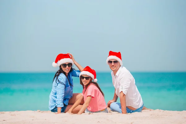 Glückliche Familie mit zwei Kindern in Santa Hat im Sommerurlaub — Stockfoto