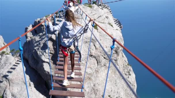 Girls crossing the chasm on the rope bridge. — Stock Video