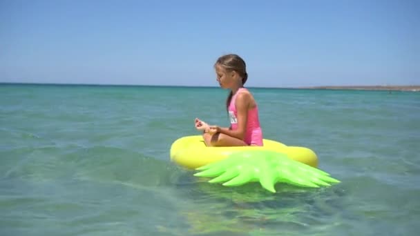 Liebenswertes Mädchen auf aufblasbarer Luftmatratze im Meer — Stockvideo