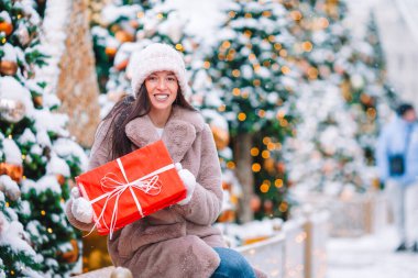 Mutlu kız yılbaşı için karların içinde köknar ağacı dalının yanında.