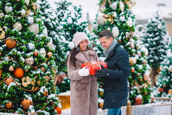 Schönes junges, fröhliches Paar feiert Weihnachten in der Stadtstraße — Stockfoto